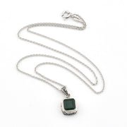 Silver necklace with a green gemstone pendant on a white background
