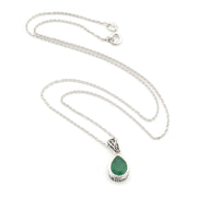Silver necklace with a green teardrop pendant on a white background