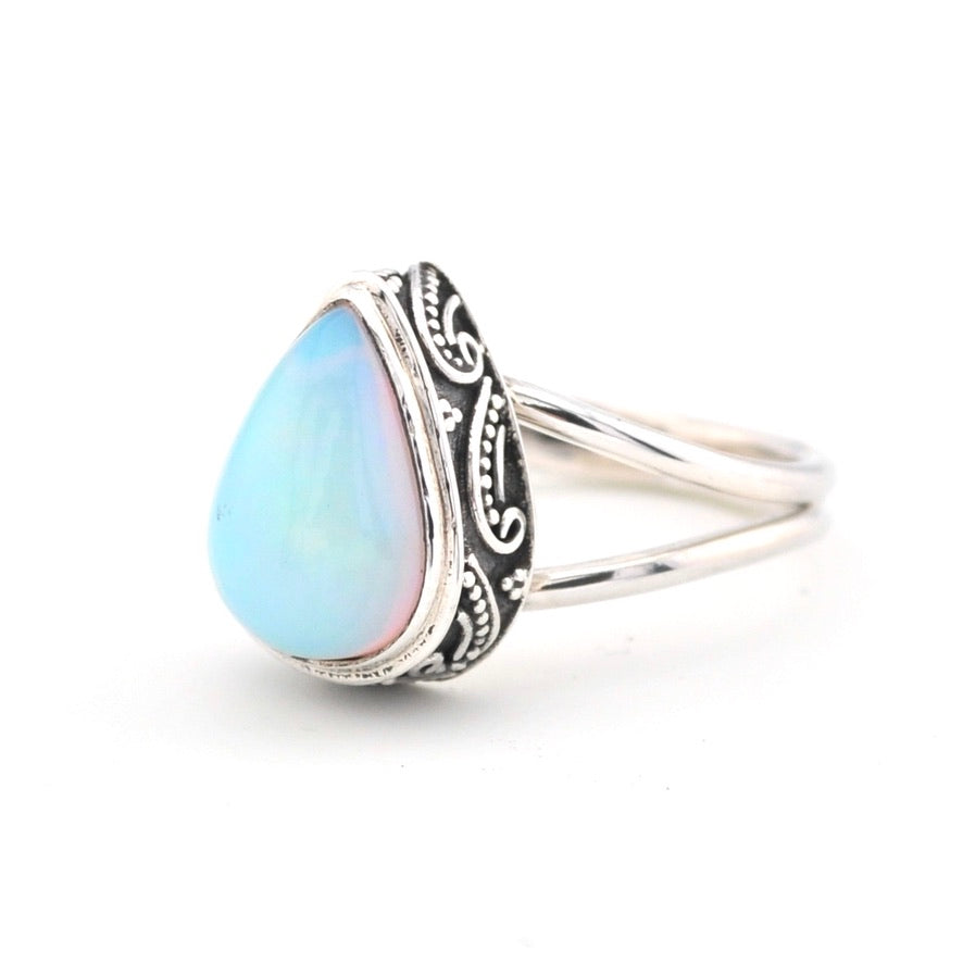 Silver ring with a blue opal stone on a white background
