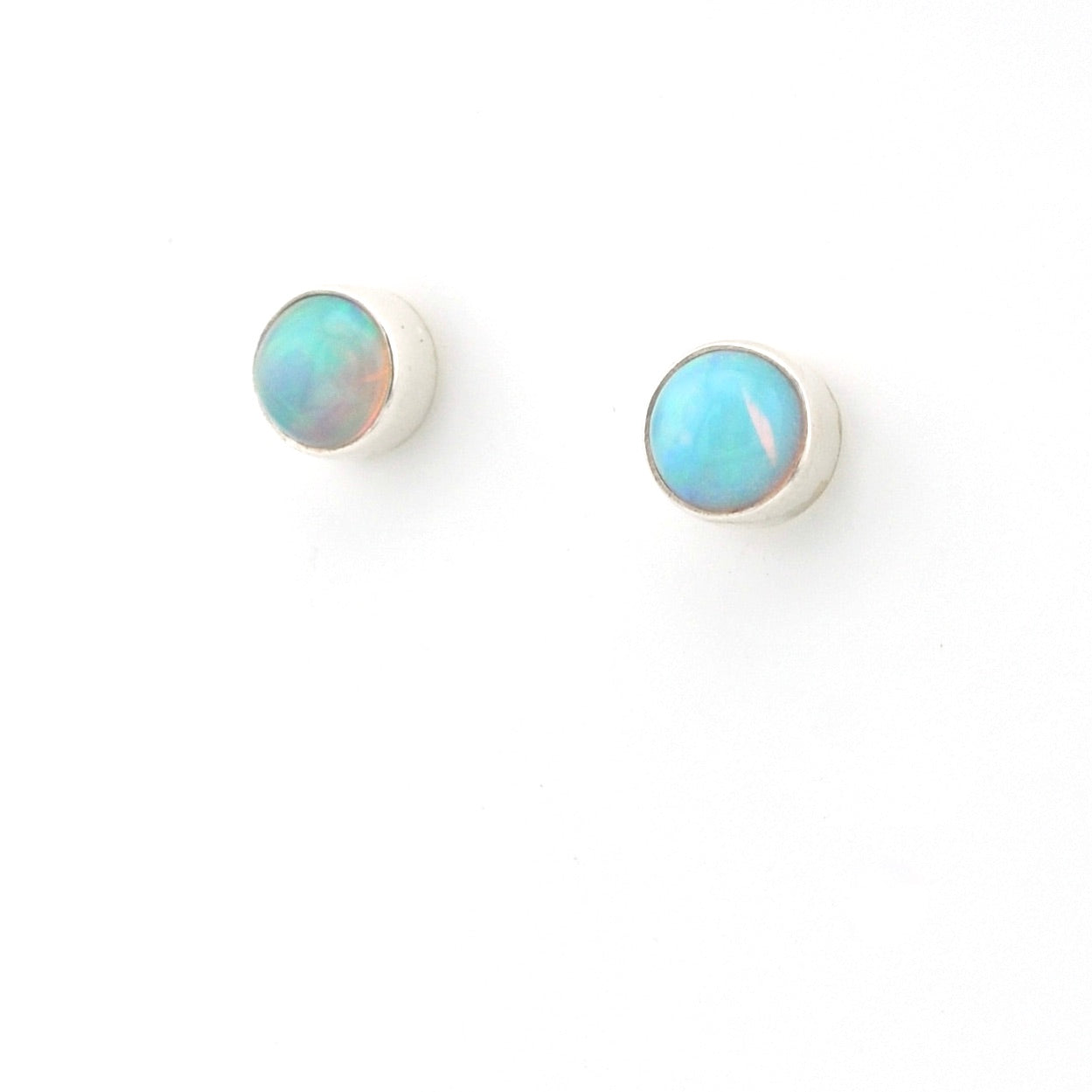 Pair of round opal earrings on a white background