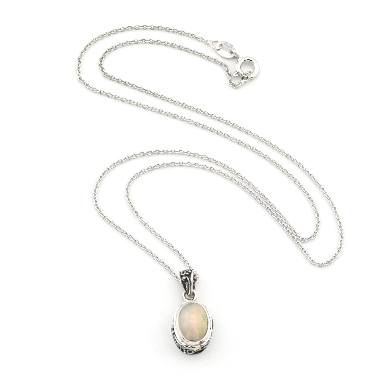 A silver chain necklace with an oval pendant featuring a white opal stone in a textured silver bezel setting, displayed on a clean white background.