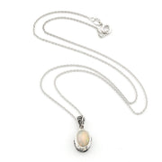 A silver chain necklace with an oval pendant featuring a white opal stone in a textured silver bezel setting, displayed on a clean white background.