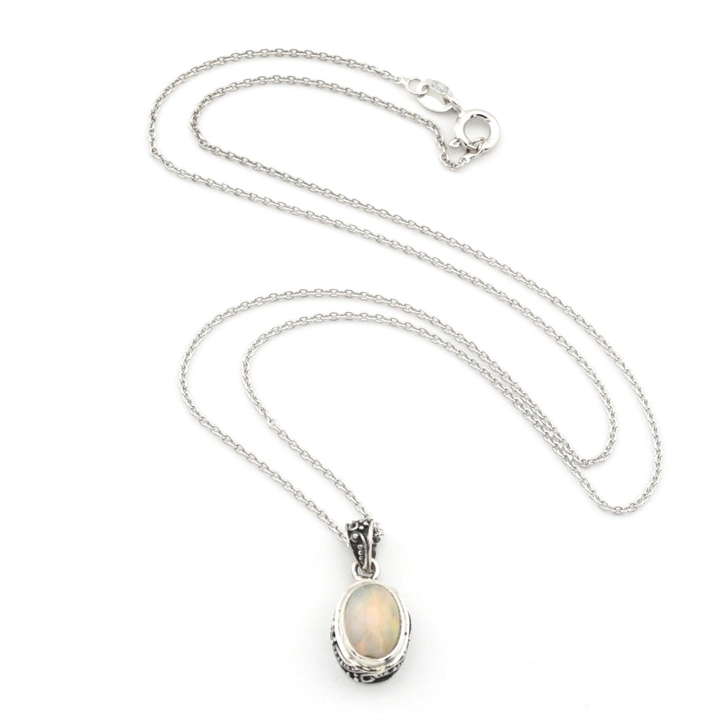 A silver chain necklace with an oval pendant featuring a white opal stone in a textured silver bezel setting, displayed on a clean white background.