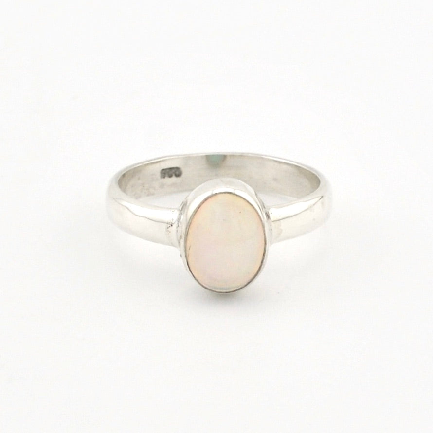 Silver ring with a white stone on a white background