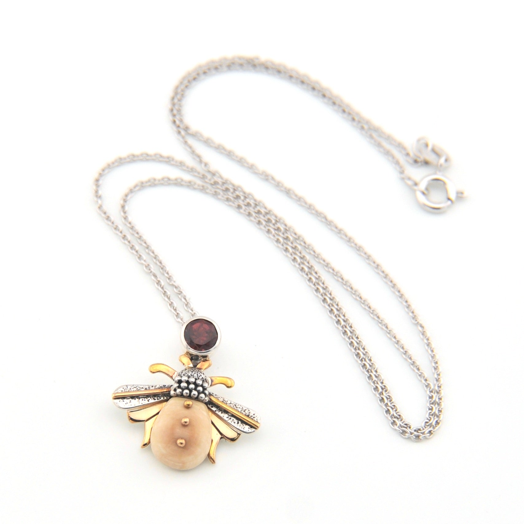 Necklace with a unique pendant featuring a gold and silver design on a white background