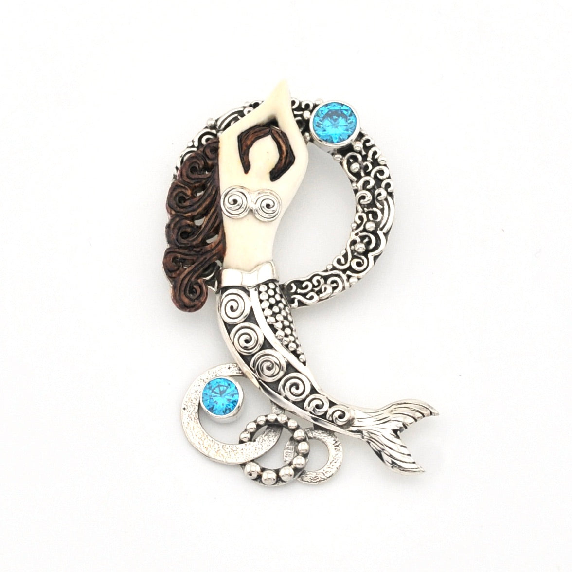Decorative pendant with intricate designs and blue gemstones on a white background