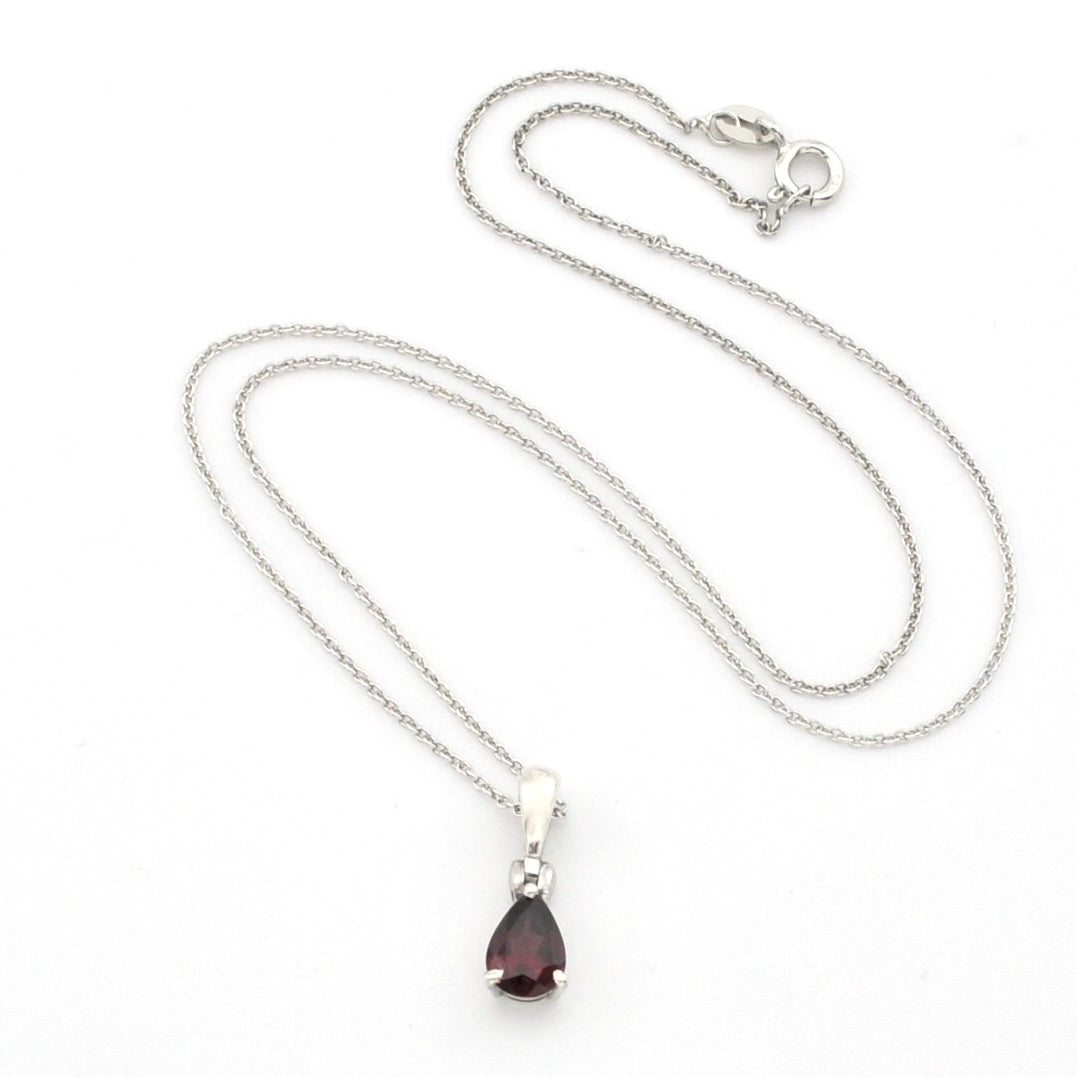 A silver chain necklace with a teardrop-shaped dark red gemstone pendant, displayed on a clean white background.