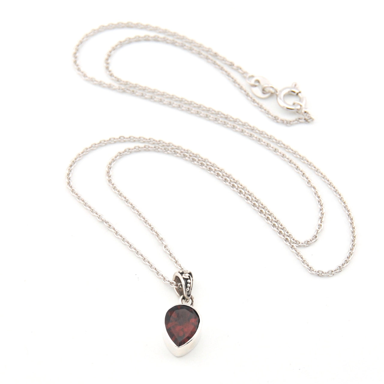 Silver necklace with a heart-shaped pendant on a white background