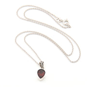 Silver necklace with a heart-shaped pendant on a white background