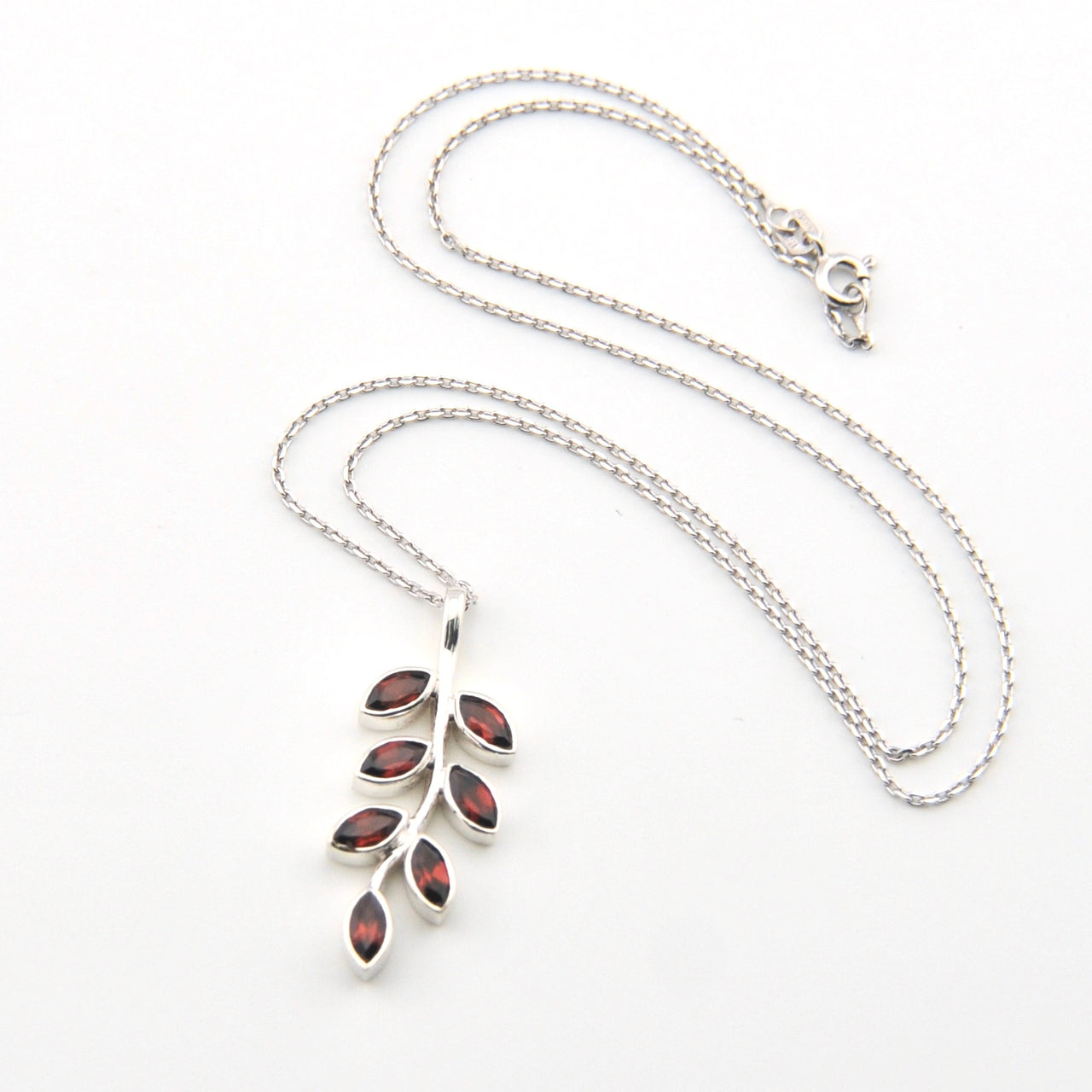 Silver necklace with a leaf-shaped pendant on a white background