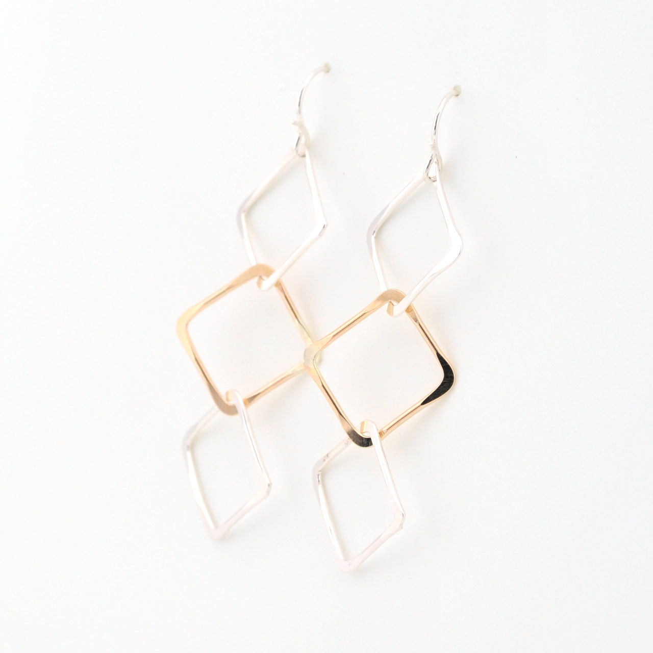 Gold geometric earrings on a white background