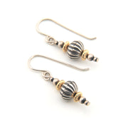 Pair of earrings with striped beads on a white background