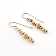 Pair of gold and silver beaded earrings on a white background