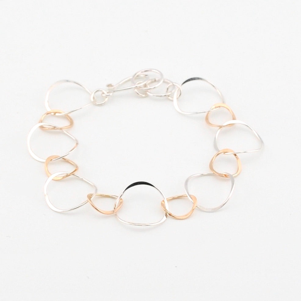 Bracelet with clear and gold circular links on a white background
