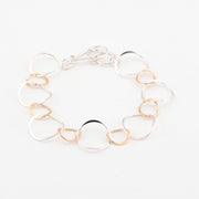 Bracelet with clear and gold circular links on a white background