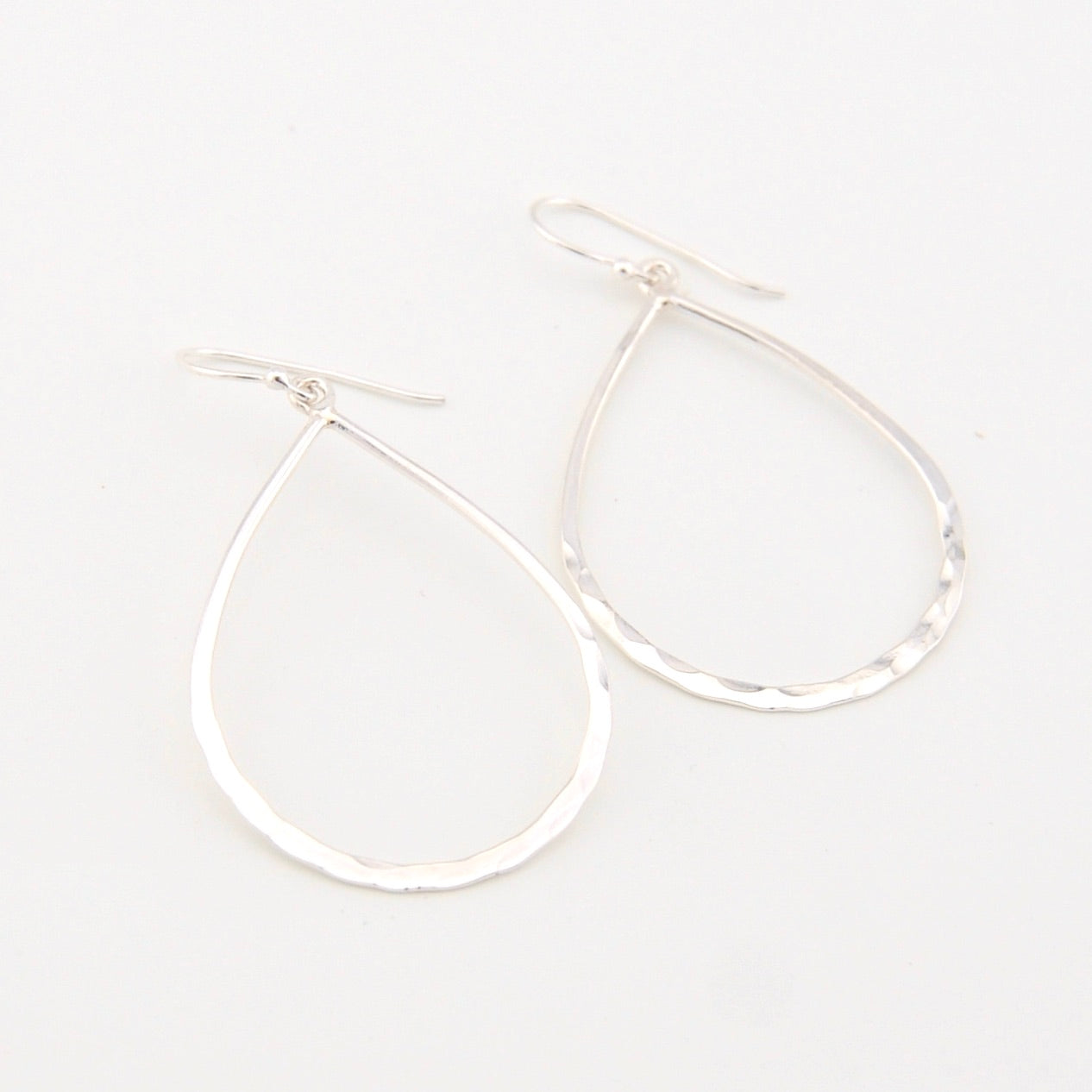 Silver hoop earrings on a light gray background