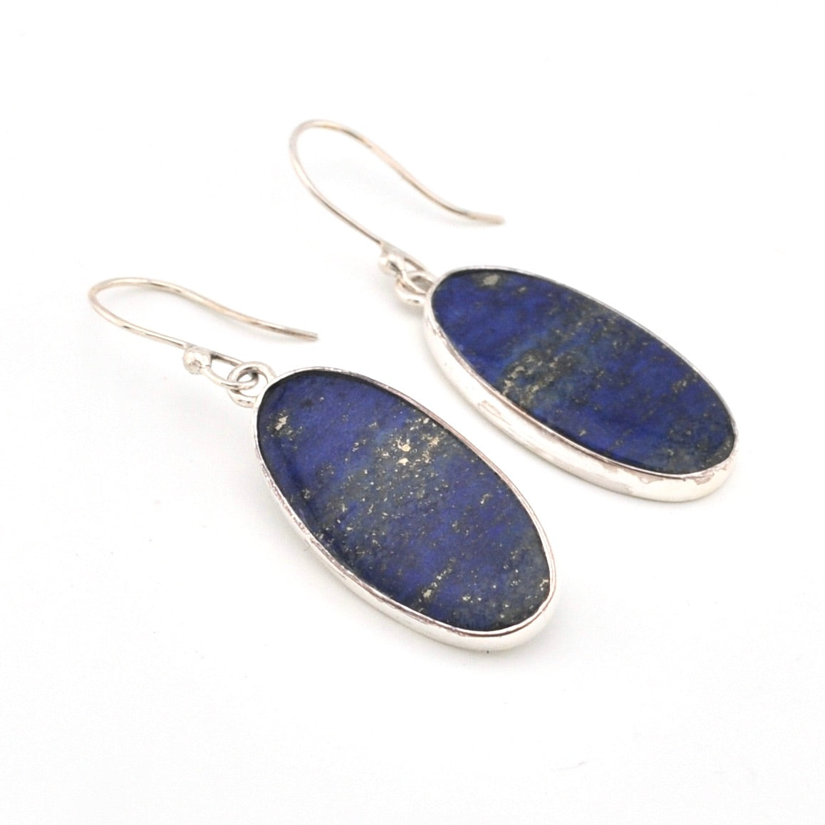 Pair of blue lapis stone earrings with silver hooks on a white background