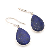 Teardrop-shaped lapis lazuli earrings with silver hooks on a white background