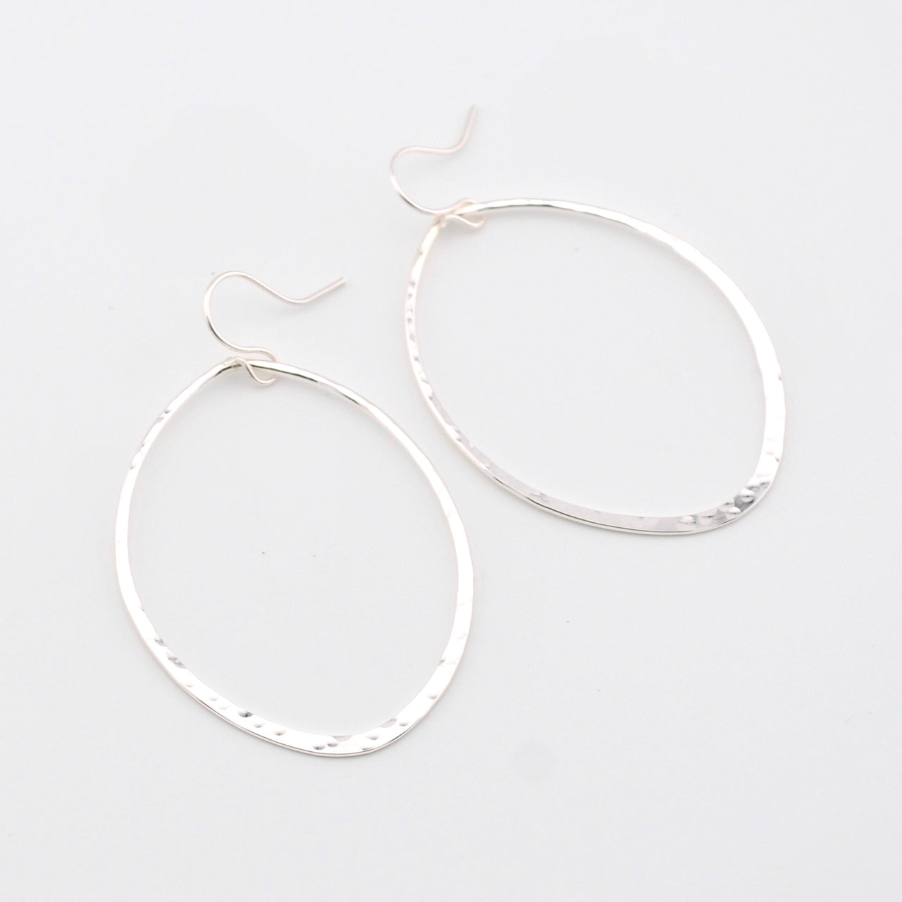 Pair of silver hoop earrings on a light gray background