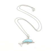 Dolphin-shaped pendant with blue stone on a silver chain against a white background
