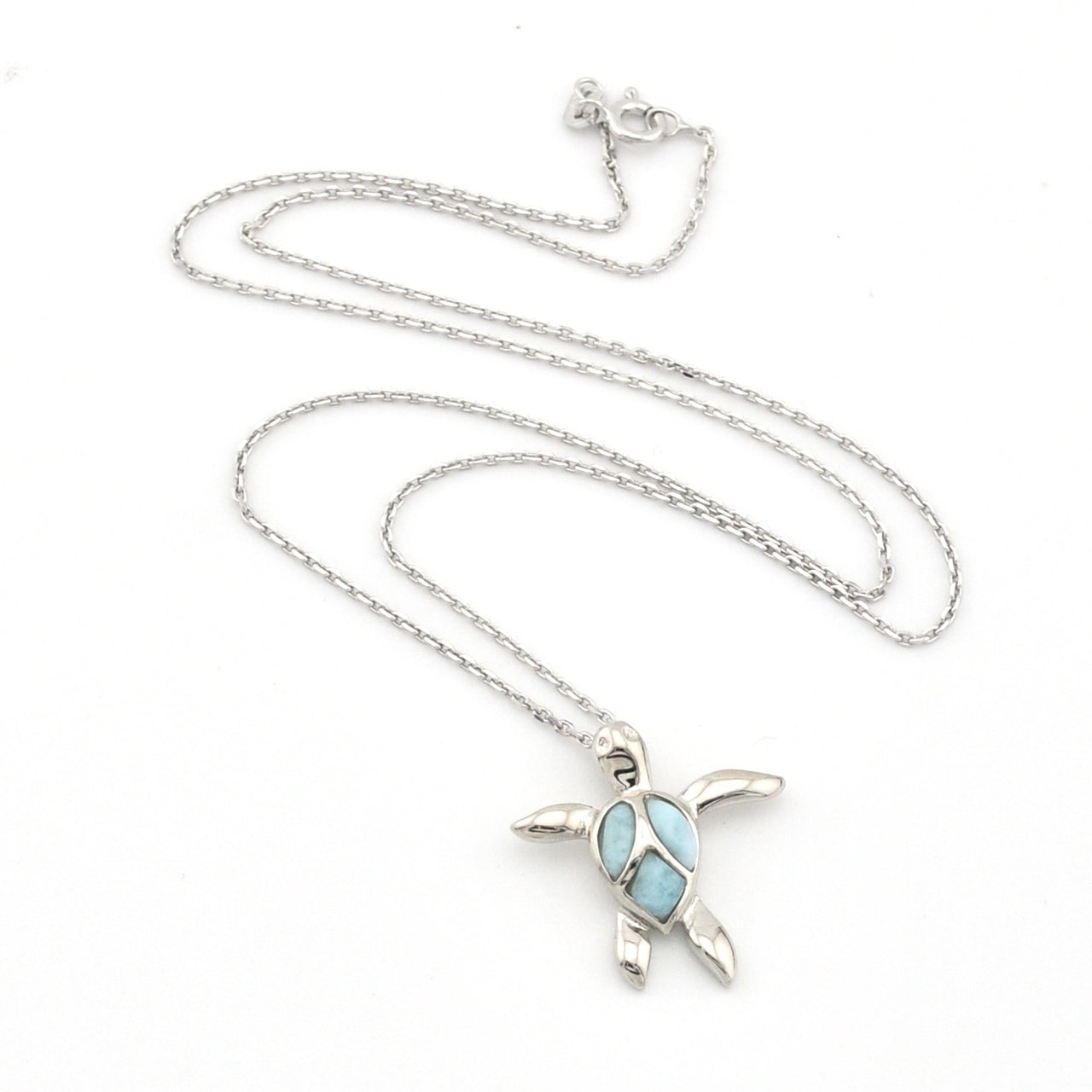 Silver turtle pendant necklace with a blue stone on a white background