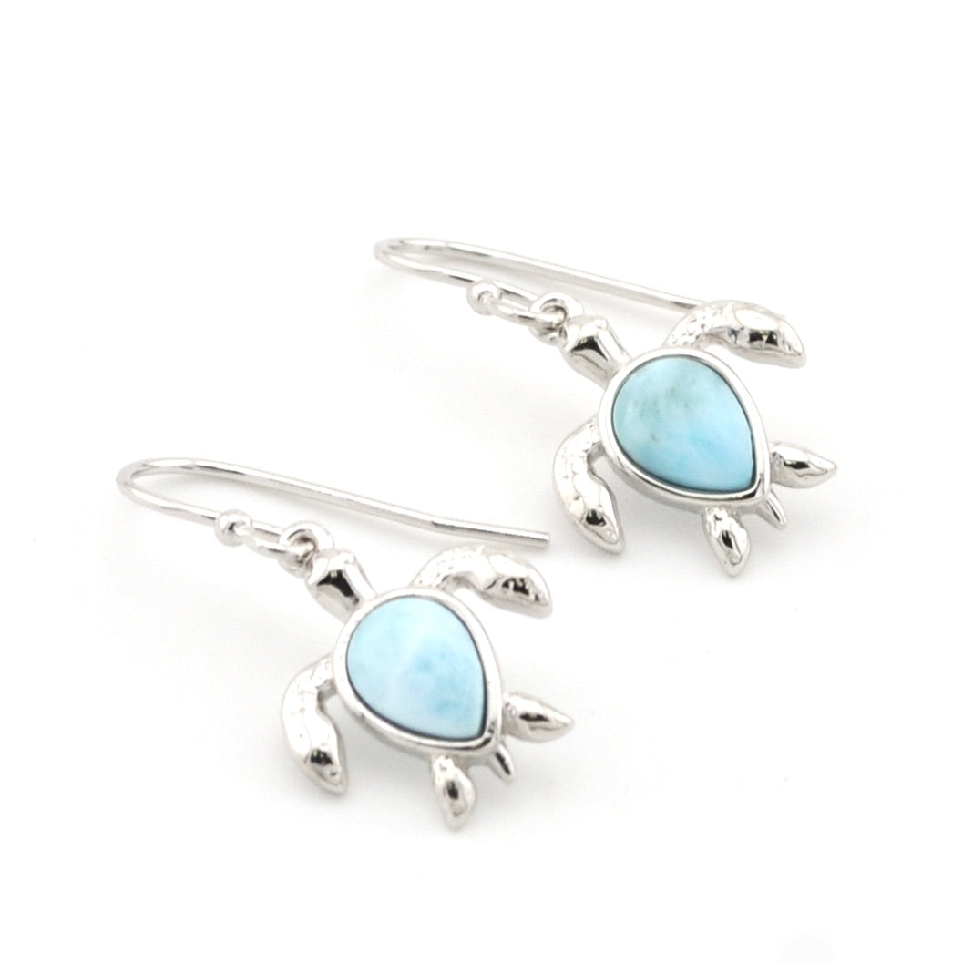 Turtle-shaped earrings with light blue stones on a white background