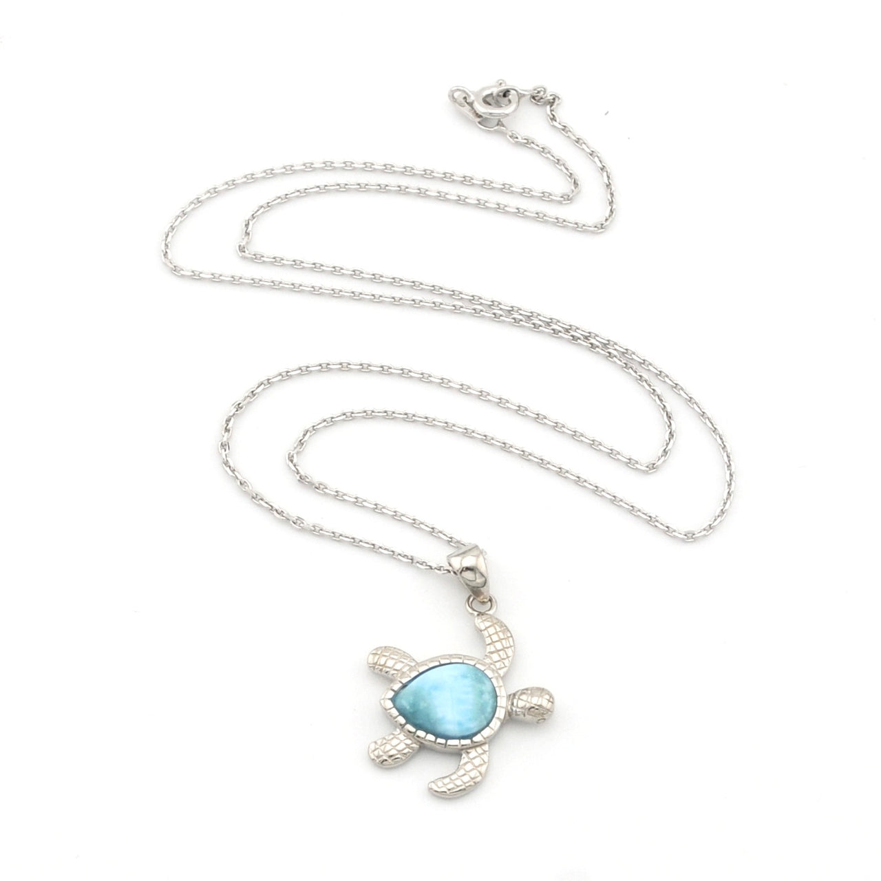 Sea turtle necklace with larimar stone on white background.
