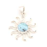 Silver sun-shaped pendant with a blue stone on a white background