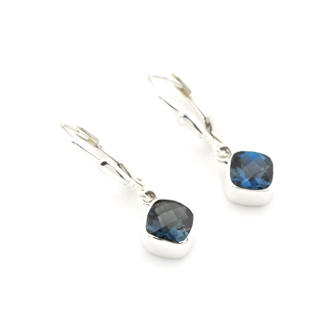 Silver earrings with blue gemstones on a white background