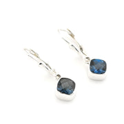 Silver earrings with blue gemstones on a white background