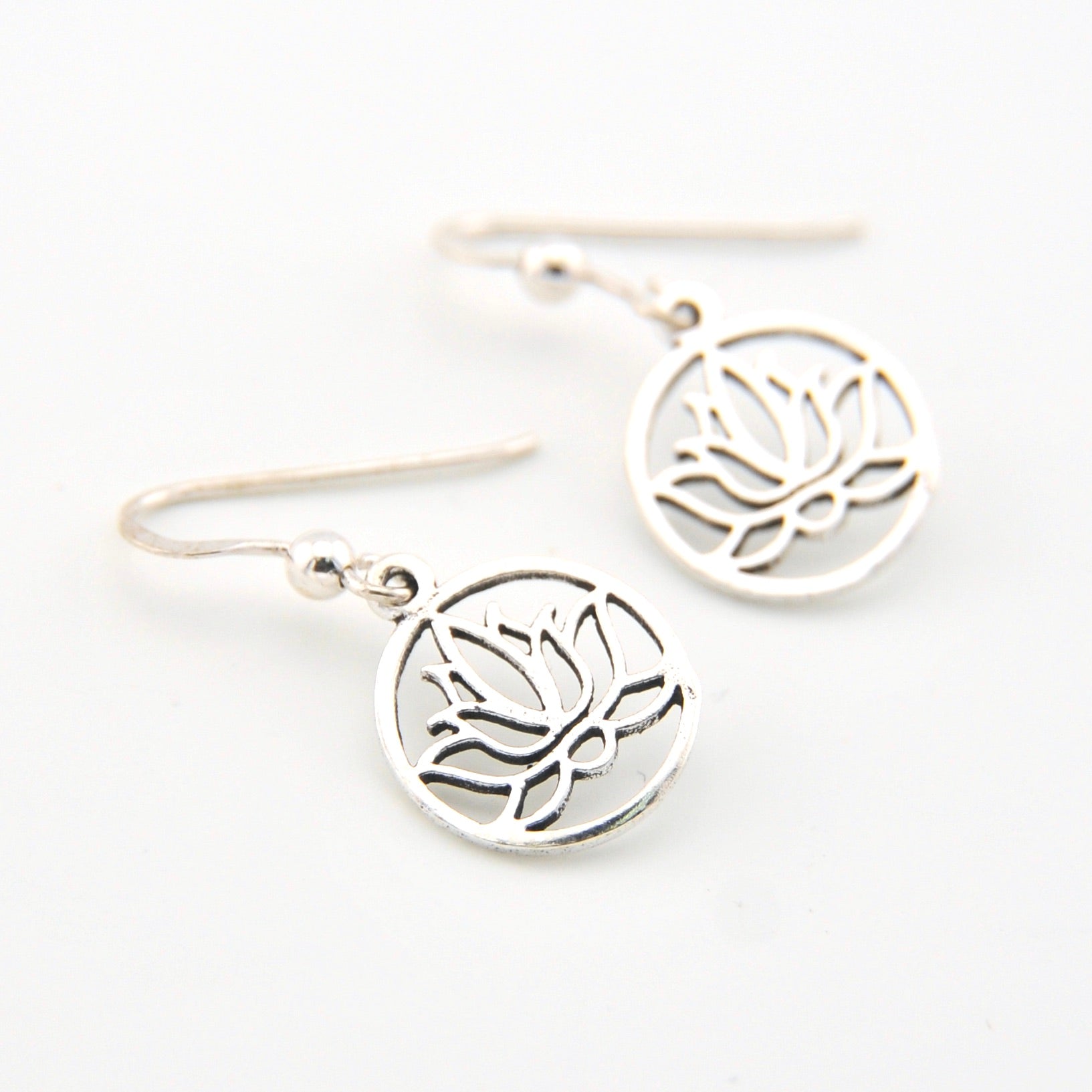 Silver lotus flower earrings on a white background