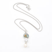 Necklace with pendant featuring a pearl and gemstone on a white background
