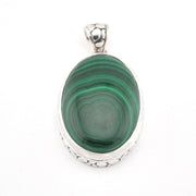 Green stone pendant with silver setting on a white background