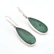 Teardrop-shaped green earrings with silver hooks on a white background