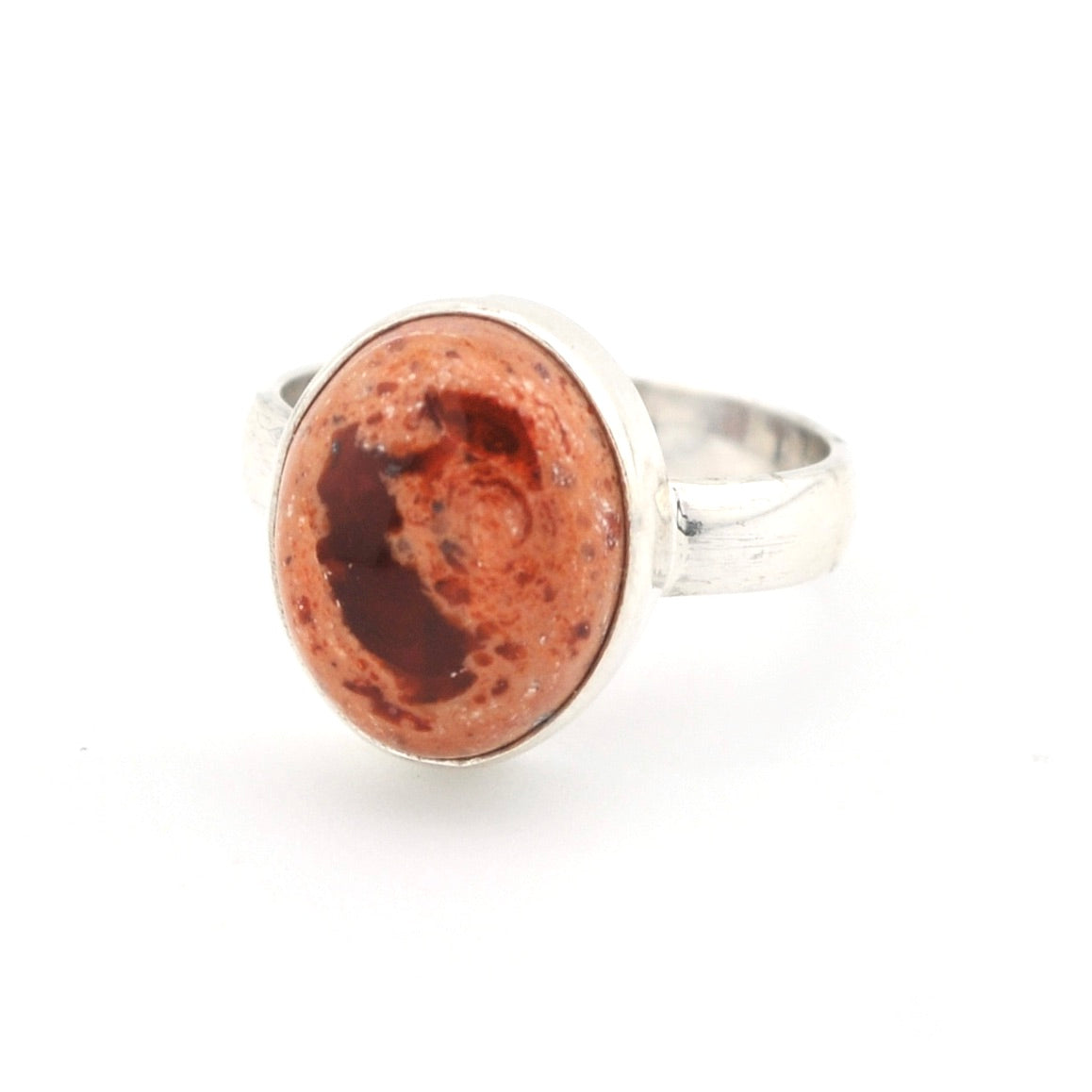 Silver ring with a red stone on a white background