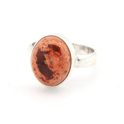 Silver ring with a red stone on a white background