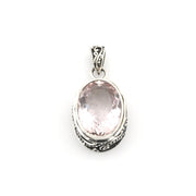 Silver pendant with a pink gemstone on a white background