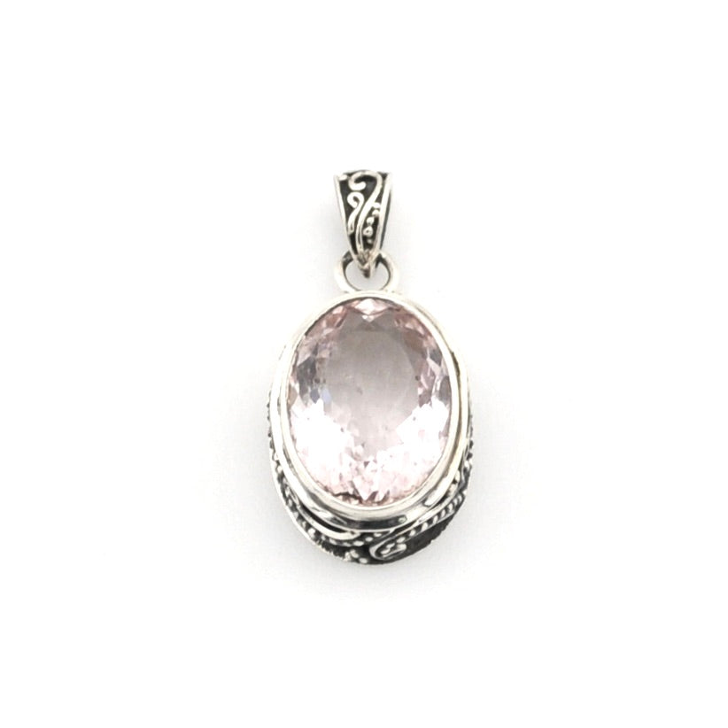 Silver pendant with a pink gemstone on a white background