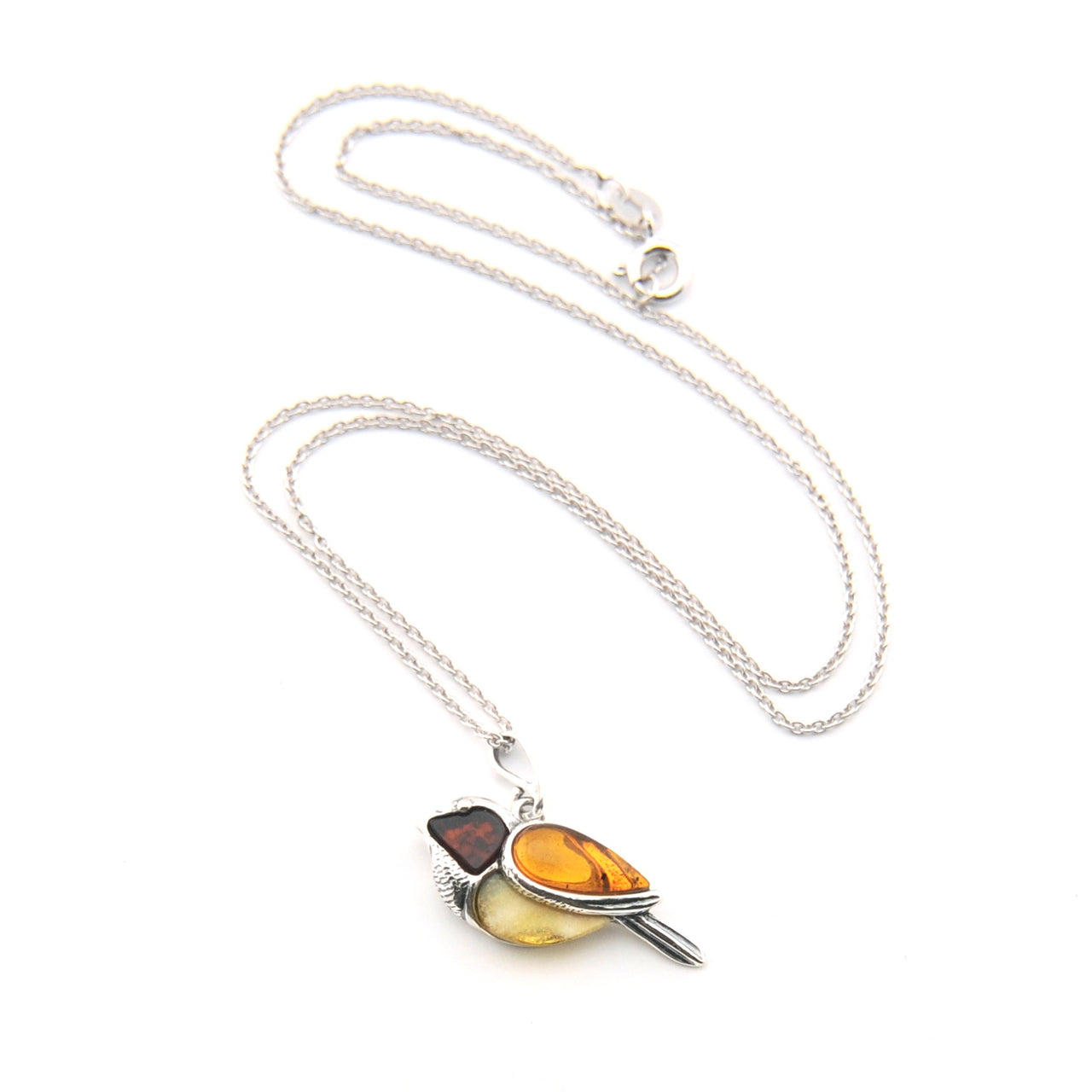 Silver necklace with a pendant featuring amber-colored stones on a white background