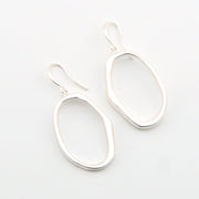 Silver oval earrings on a light gray background
