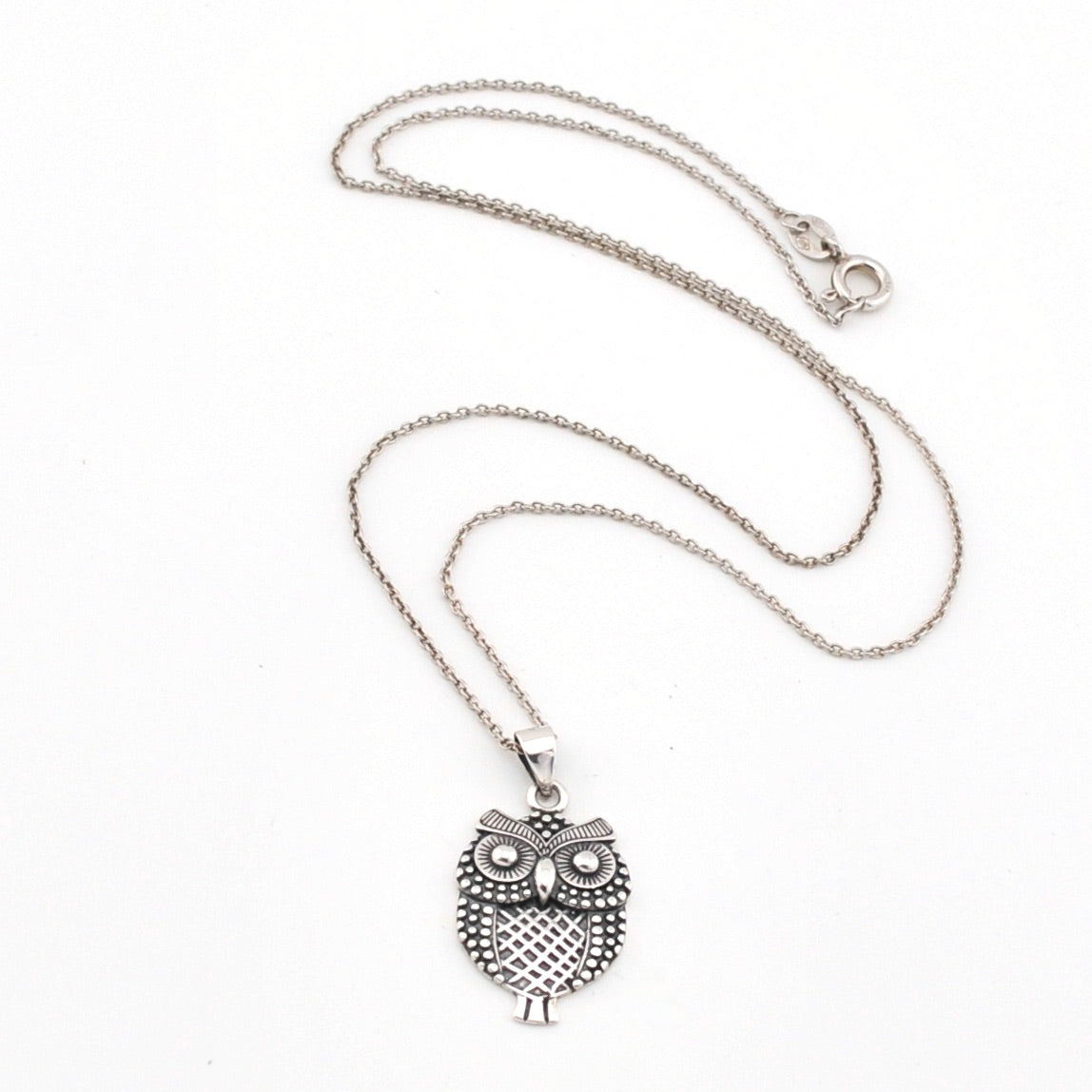 Silver owl pendant necklace on a white background