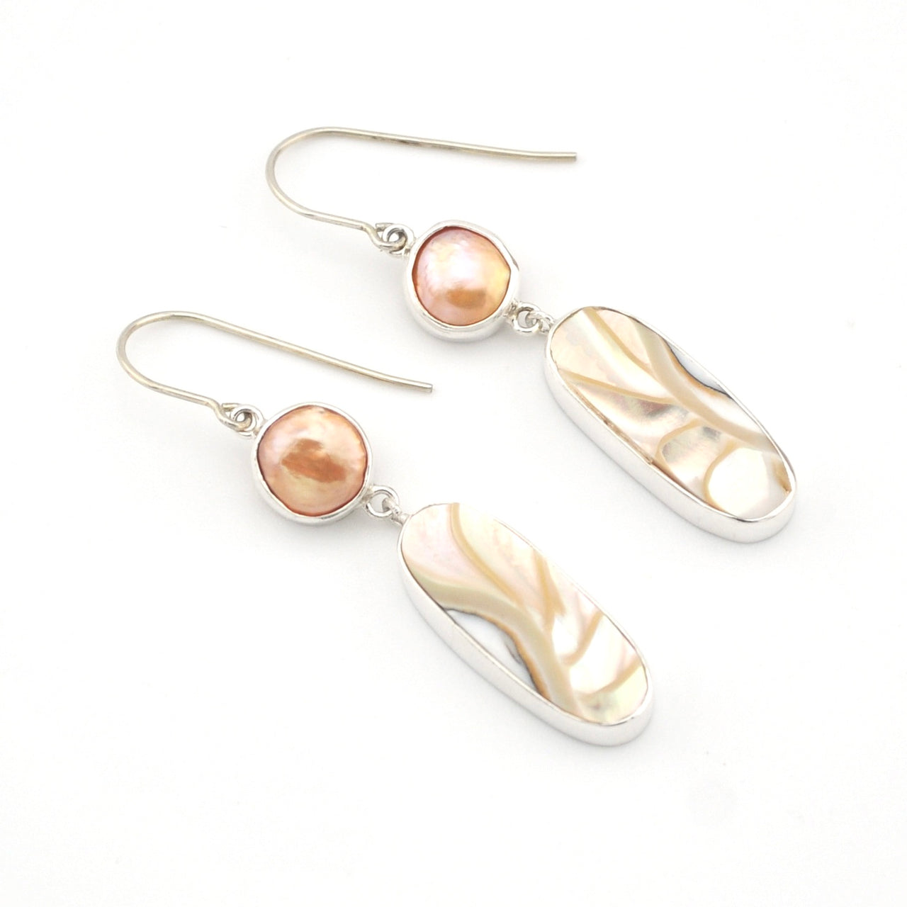 Pair of earrings with pearls and silver hooks on a white background
