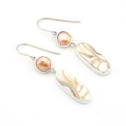 Pair of earrings with pearls and silver hooks on a white background