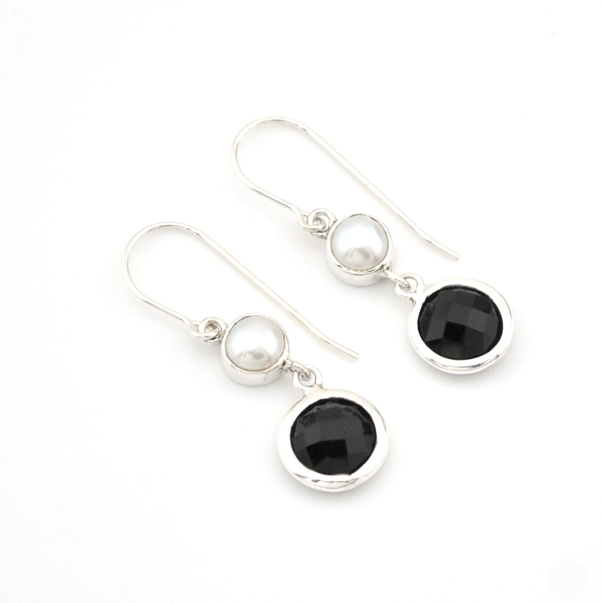 Pair of earrings with black and white gemstones on a white background