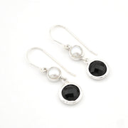 Pair of earrings with black and white gemstones on a white background