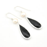 Black teardrop earrings with pearl accents on a white background
