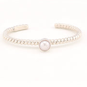 Silver bracelet with a pearl on a white background
