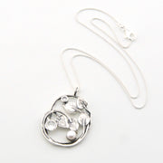 Silver necklace with a leaf-shaped pendant on a white background