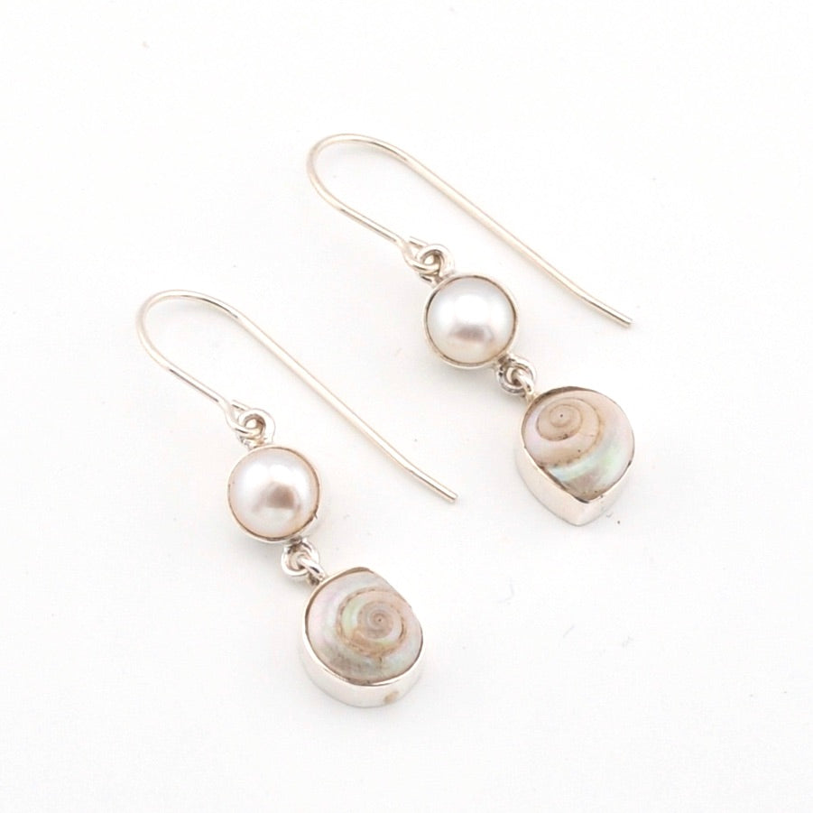 Pair of earrings with pearls and shell elements on a white background
