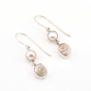 Pair of earrings with pearls and shell elements on a white background